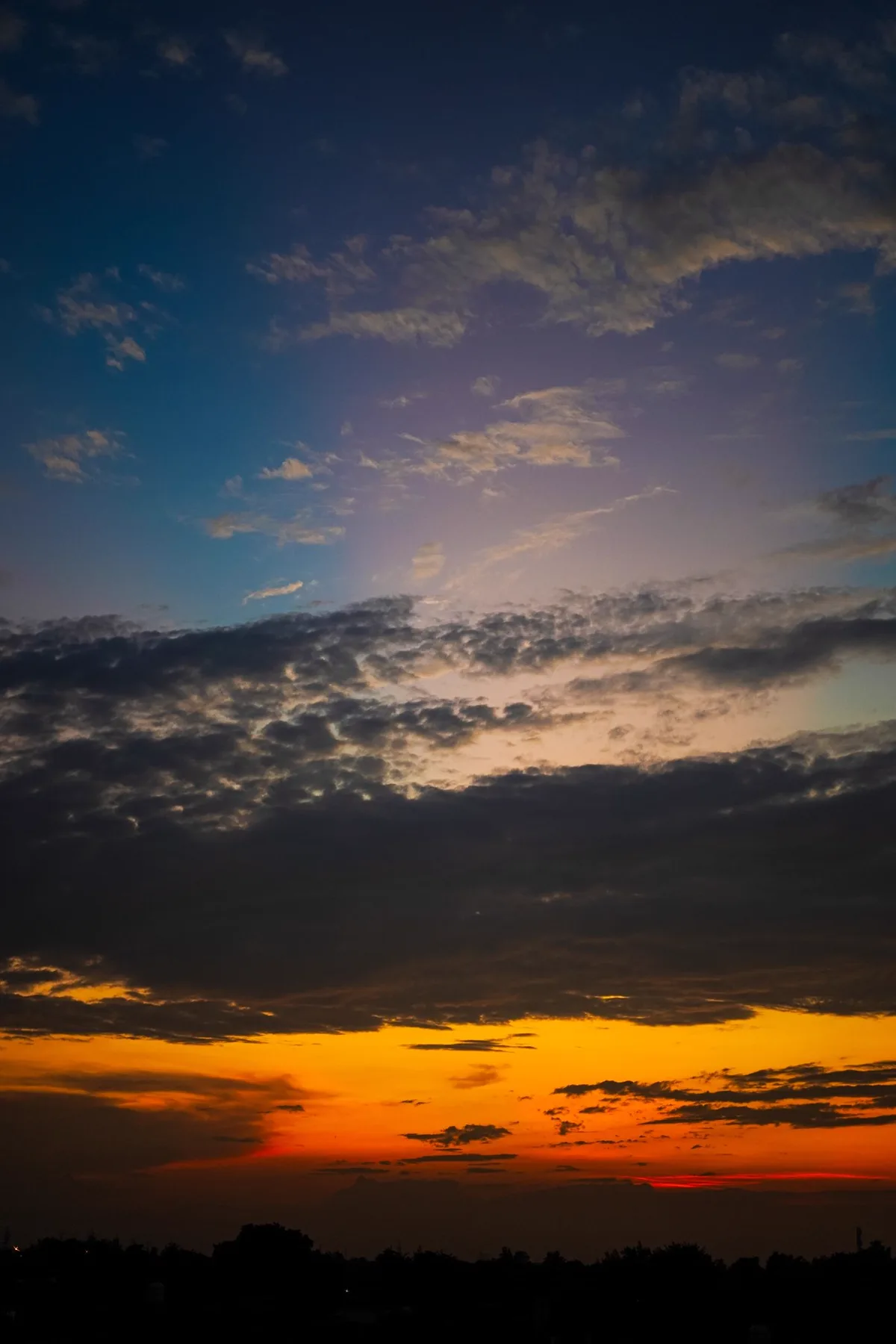 A dramatic dawn sky with broken cloud over a distant horizon
